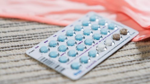 Set of birth control pills on a beige surface