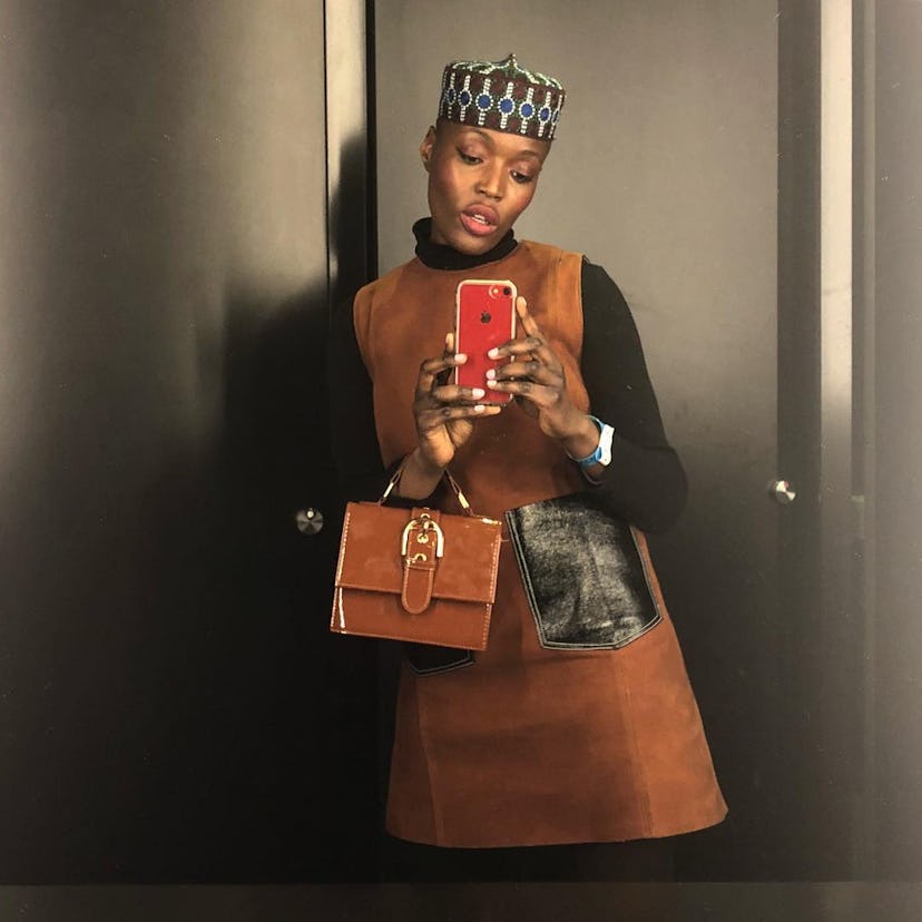 Folasade Adeoso taking an elevator mirror selfie while wearing a brown dress 