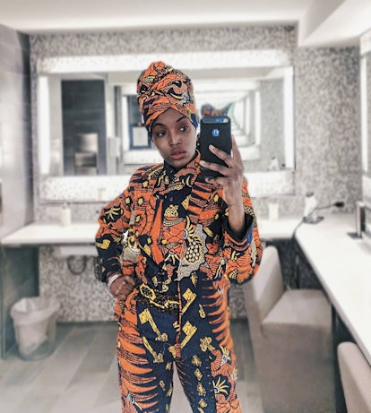 Adeoso taking a mirror selfie in an African outfit that she designed