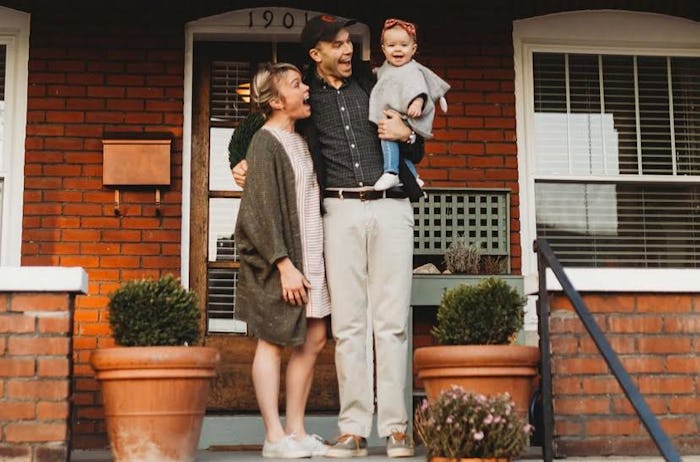 Parents and their baby standing on their front steps