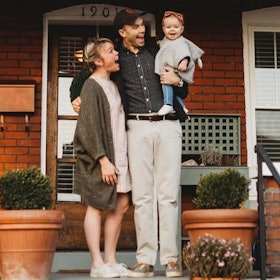 Parents and their baby standing on their front steps
