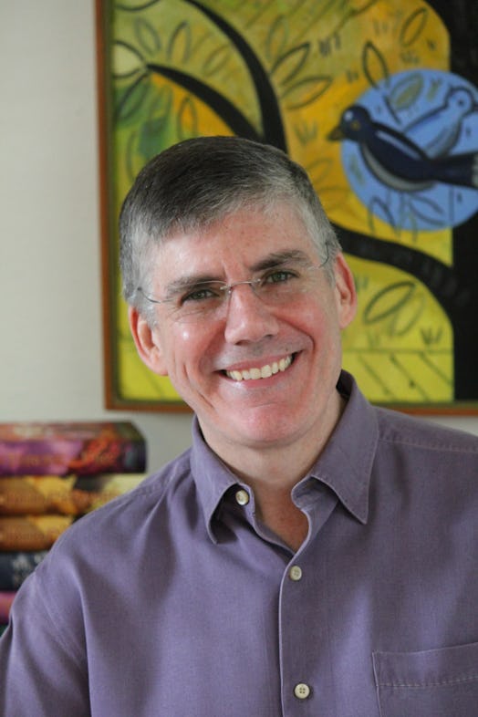 Rick Riordan posing for a photo in a purple shirt