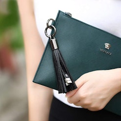 A woman in a white shirt holding a dark-green purse found on Amazon