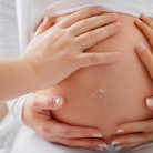 People touch the belly of a surrogate mother.