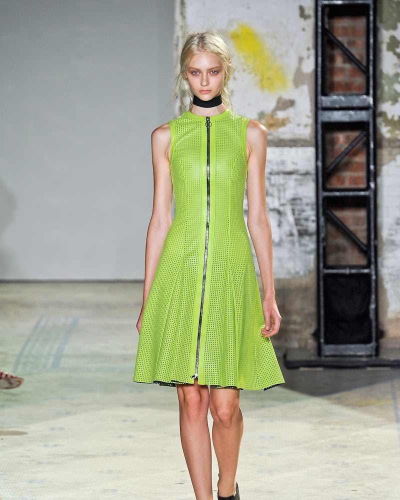 A model walking in a slime green mini dress