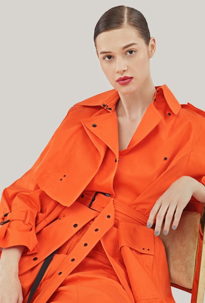 A female model posing in an orange dress