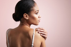 A woman with a low bun applying squalane oil with beauty benefits 