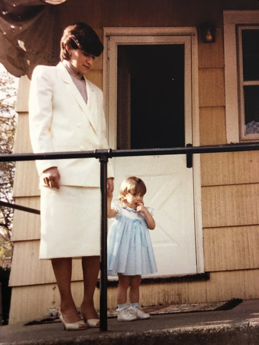 Toddler Lauren Caruso posing in a blue dress with her mom wearing a white blazer and skirt