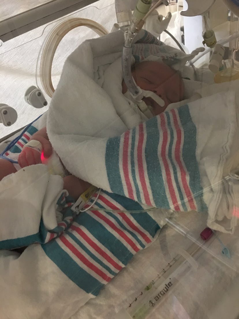 A baby at the NICU in an incubator covered with a blanket
