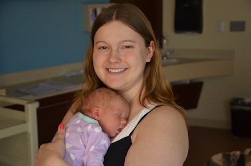 A woman that is experiencing postpartum anxiety, holding her baby close to her chest 