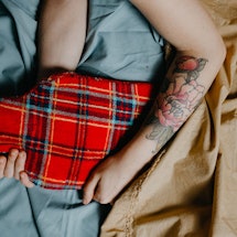 A woman holds a hot water bottle to get rid of period cramps at night. 