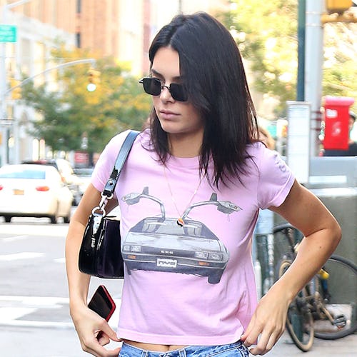 Kendall Jenner styling jeans and a t-shirt while walking down a street