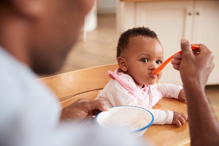 A father spoon-feeding a baby