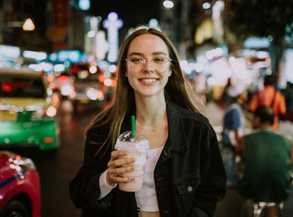 Woman smiling holding a Starbucks drinks who neesd a caption for Instagram.