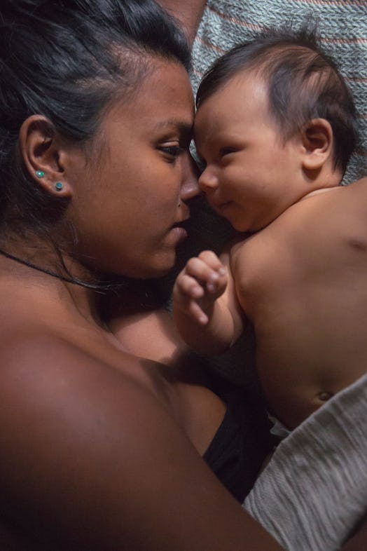 Mom and baby lying in bed face to face staring at each other lovingly