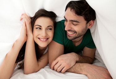 A woman and a man relaxing on a bed