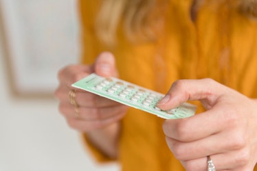 A woman holding birth control pills in her hands 