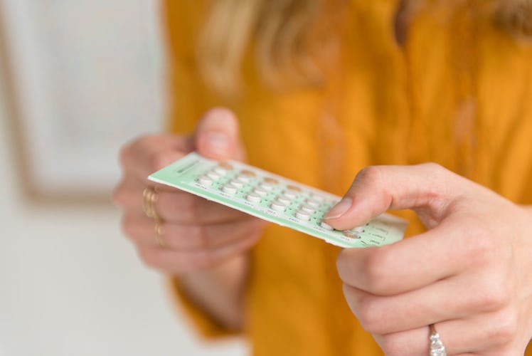 A woman holding birth control pills in her hands