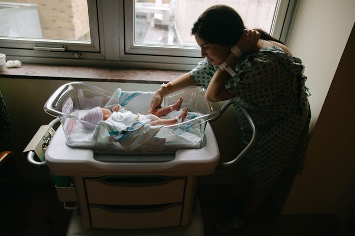 Mom leaning over her newborn baby