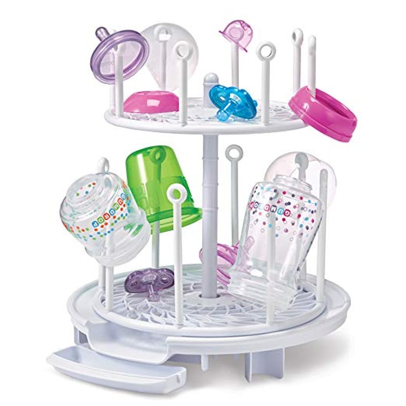 A white drying rack for baby bottles and their parts