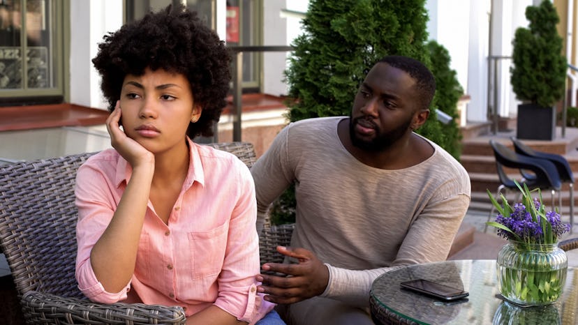 A man trying to talk to a woman who is looking away in anger.