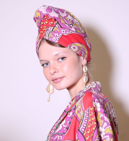 A model wearing shell jewelry with a turban