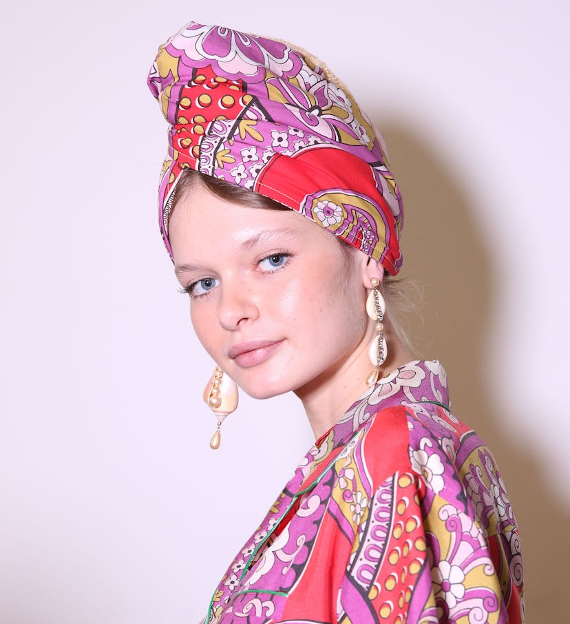 Model wearing floral print dress,matching turban on head and shell earrings