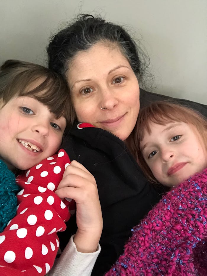 A mother taking a selfie with her two daughters