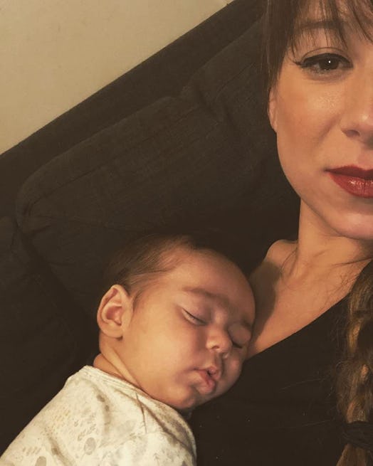 Danielle Campoamor taking a selfie with her newborn sleeping on her chest.