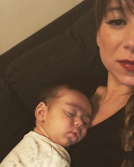 Danielle Campoamor taking a selfie with her newborn sleeping on her chest.