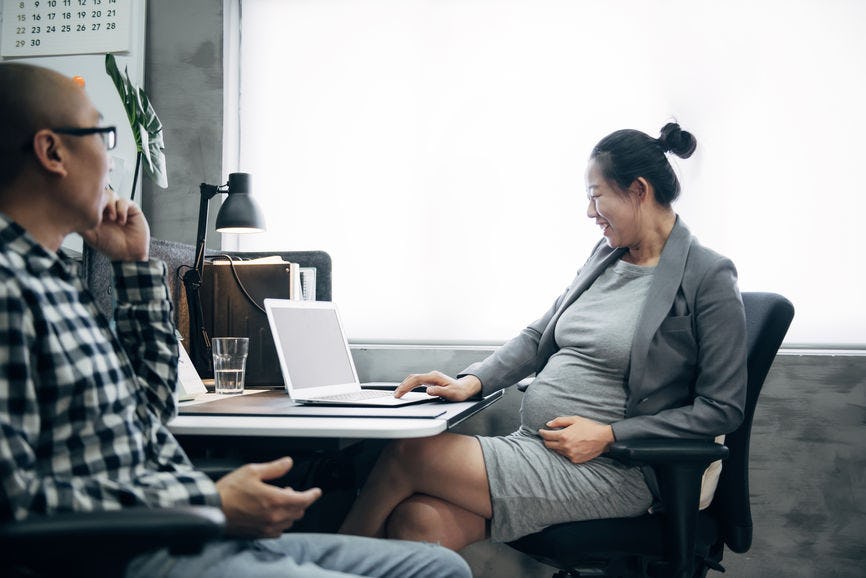 A pregnant mom sitting at work