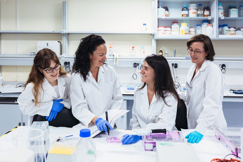 Four smiling women in the laboratory taking samples for analysis.