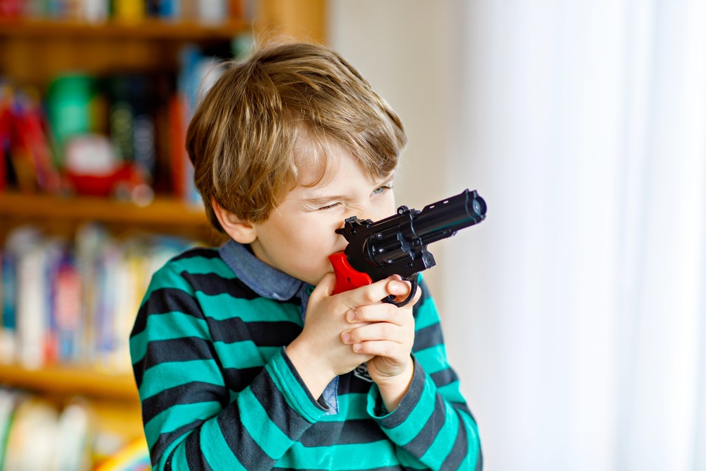 gun pointed at baby stock photo
