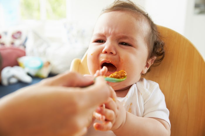 A parent pleasing a baby girl while feeding her