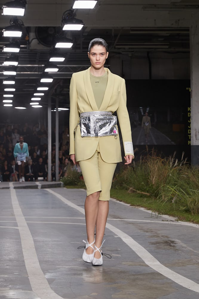 A model walking the runway at an Off-White show in a beige blazer and matching bermuda shorts