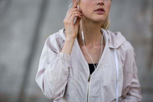 A girl listening to a true crime podcast with her earphones while running
