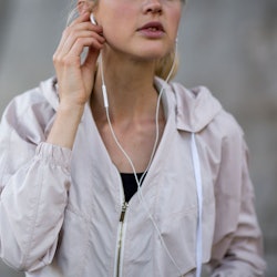 A girl listening to a true crime podcast with her earphones while running