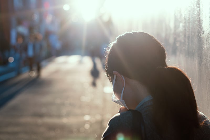 A woman with asthma walking down a street with a mask