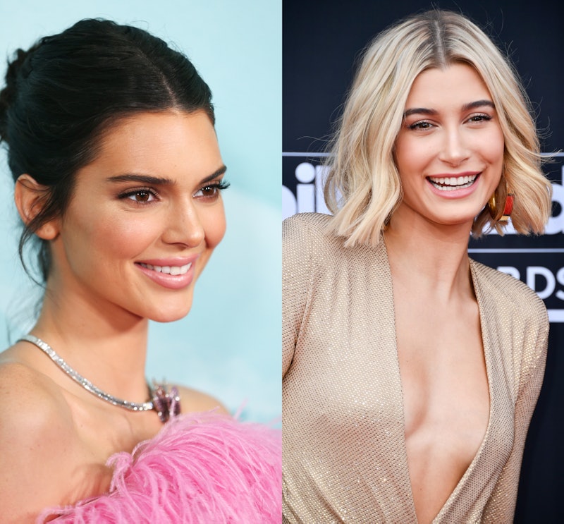 Kendall Jenner with an updo in a pink feather dress next to Hailey Baldwin in a golden-colored body ...