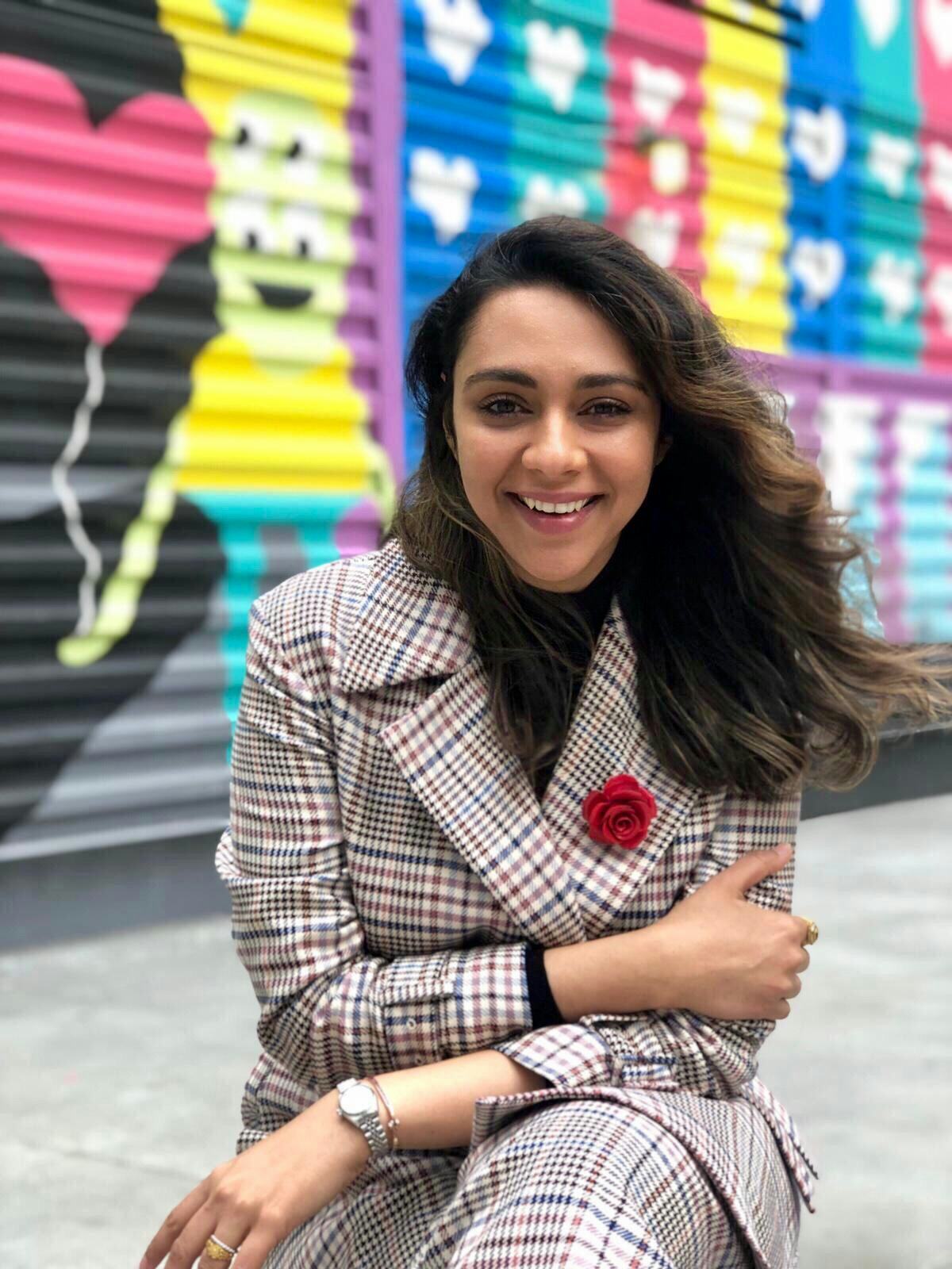Parizaad Khan Sethi smiling in front of a wall full of colorful graffiti