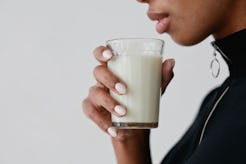 A woman holding a glass of synthetic breast milk