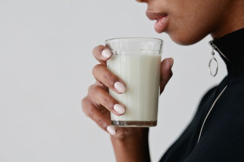 A woman holding a glass of synthetic breast milk