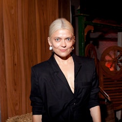 Celebrity Stylist Kate Young posing for a photo in a black suit, with her blonde hair in a low bun.