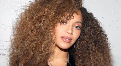 A closeup of Beyoncé with a light brown lip and her natural curls 