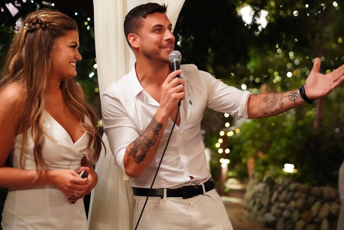 Jax's speaking with a microphone and his sister next to him in a white dress