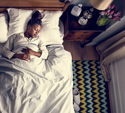 A pregnant woman sleeping in her bed 