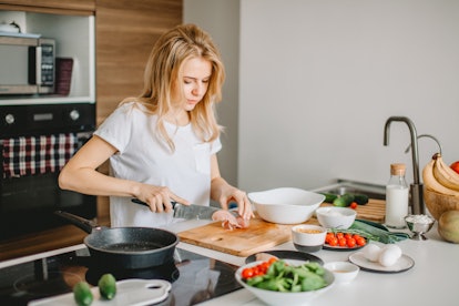 A woman in the kitchen cooking in order to boost her immune system