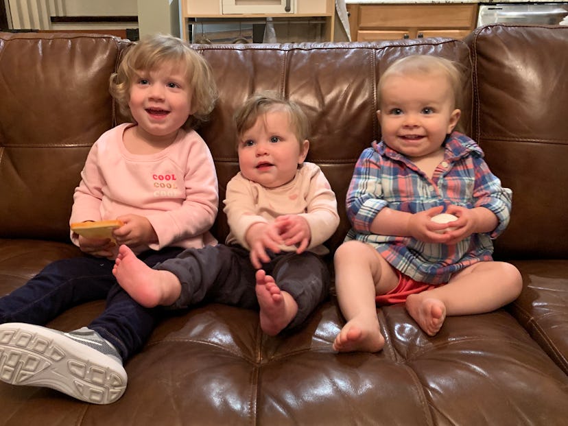 Four baby girls sitting on a sofa