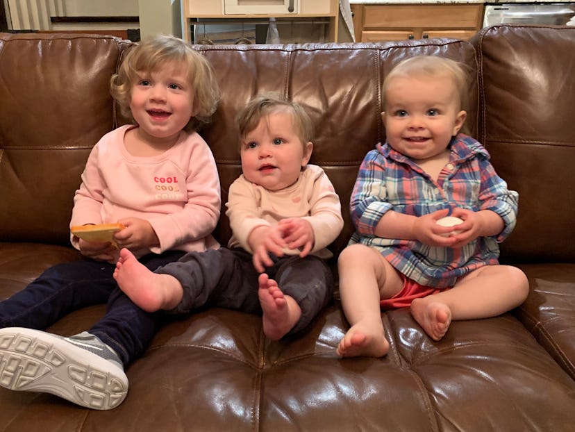 Four baby girls sitting on a sofa