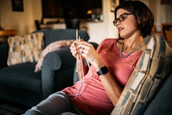 Pregnant woman with an eating disorder wearing glasses and a pearl necklace while checking her phone